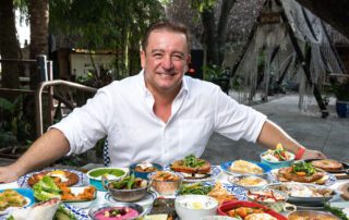 A man sitting in front of a table full of food.