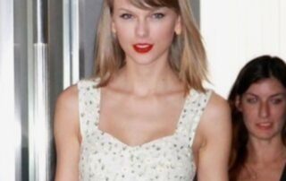 Woman with blonde hair and red lipstick wearing a white dress.