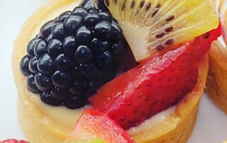 Mini fruit tart with blackberry, strawberry, and kiwi slices.