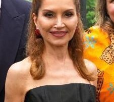 A woman in a strapless black and white dress smiling.