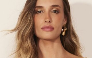 Close-up portrait of a woman with long hair and gold earrings.