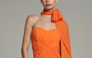 Woman in elegant orange strapless dress with matching scarf.