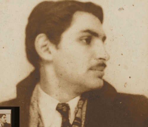 Young man with a slight smile against a gray background.