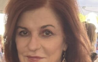Portrait of a woman with red hair and earrings.
