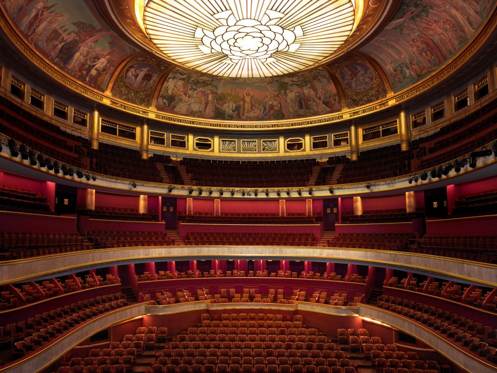 Interior view of an ornate, circular theater with a decorative ceiling.