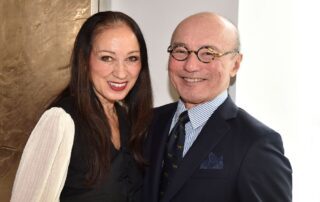 Smiling couple posing together in formal attire indoors.