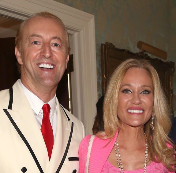 Man in white suit with woman in pink.