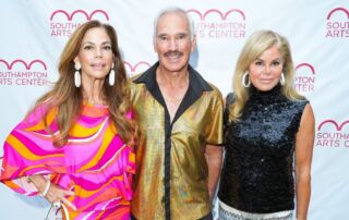 Three well-dressed individuals posing at Southampton Arts Center event.
