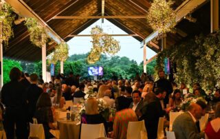 Outdoor gala dinner with hanging lights.