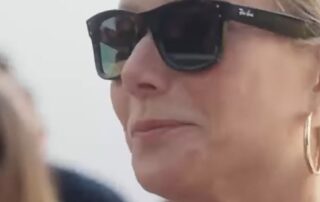 Woman wearing sunglasses and hoop earrings.