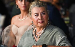 Elegant woman with pearl necklace and watch.