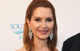 Woman with auburn hair and sparkly earrings.