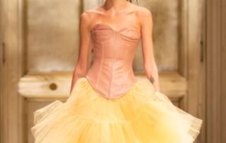 Model in pink corset and yellow tulle skirt.