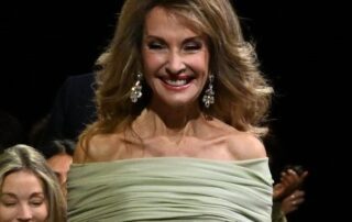 Smiling woman in off-the-shoulder gown.