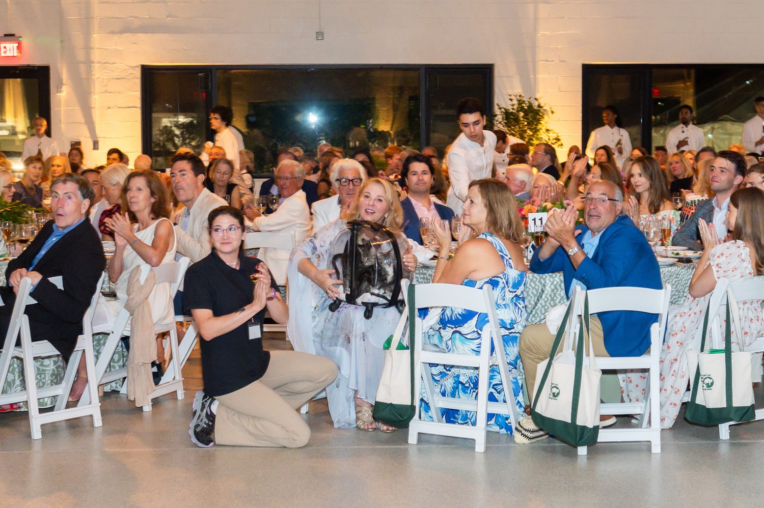 People enjoying a lively indoor event with applause and smiles.