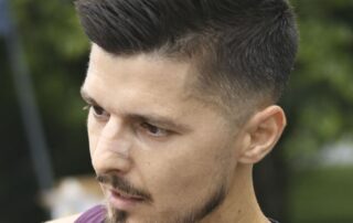 Man with a stylish short haircut and trimmed beard.