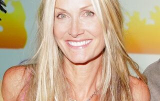 Smiling woman with long blonde hair and a silver necklace.