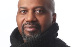 Portrait of a confident man wearing a black knitted sweater with a high collar.