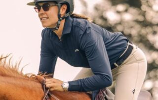 Woman in helmet riding a horse outdoors.