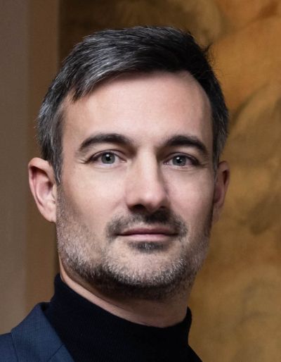 Portrait of a middle-aged man with short hair and light stubble.