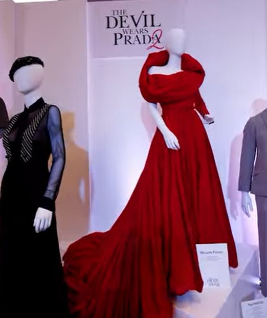 Elegant red evening gown with dramatic collar on a mannequin.